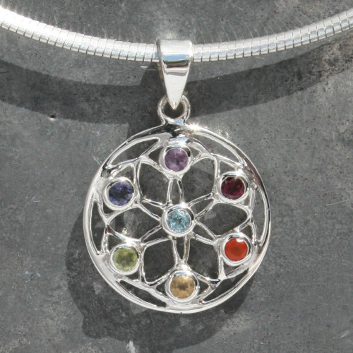 sterling silver Chakra Flower, Seed of Life Pendant contains a corresponding stone for each of the seven Chakras, starting at the Crown with Blue Topaz (centre of the Seed of Life) followed by: Amethyst, Iolite, Peridot, Citrine, Carnelian and Garnet at the Root Chakra.